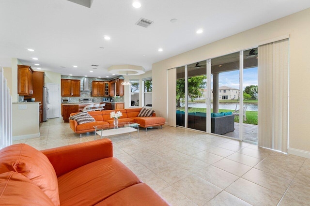 living area featuring light tile patterned flooring, baseboards, visible vents, and recessed lighting