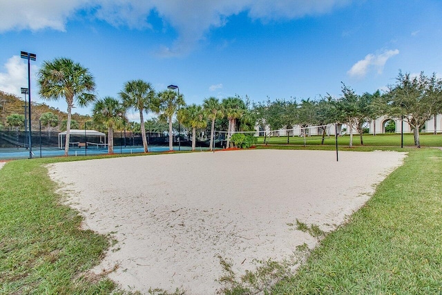 view of property's community with a lawn and fence