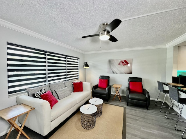 living room with ceiling fan, a textured ceiling, ornamental molding, and wood finished floors