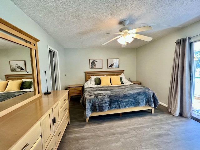 bedroom featuring dark wood-style floors, ceiling fan, a textured ceiling, and baseboards