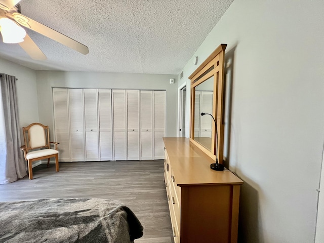 bedroom with dark wood-type flooring, ceiling fan, and a textured ceiling