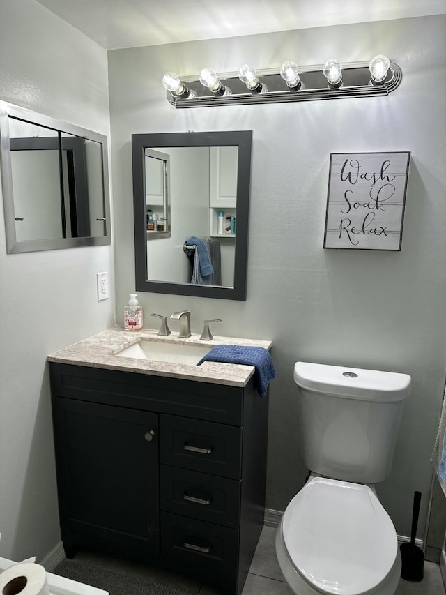 half bathroom with baseboards, vanity, and toilet