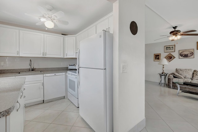 kitchen featuring light tile patterned floors, light countertops, white cabinetry, a sink, and white appliances