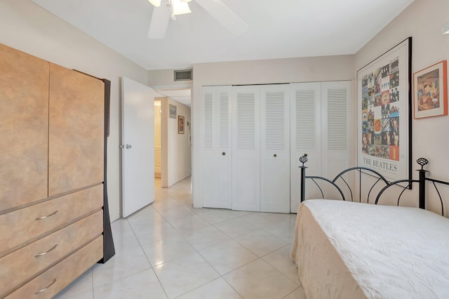 bedroom featuring a ceiling fan, a closet, visible vents, and light tile patterned floors