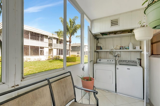 washroom featuring a wealth of natural light, laundry area, light tile patterned flooring, and washer and clothes dryer