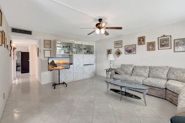 living area with a ceiling fan, visible vents, and light tile patterned flooring