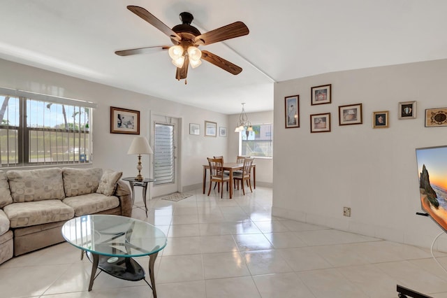 living room with light tile patterned floors, a ceiling fan, and baseboards