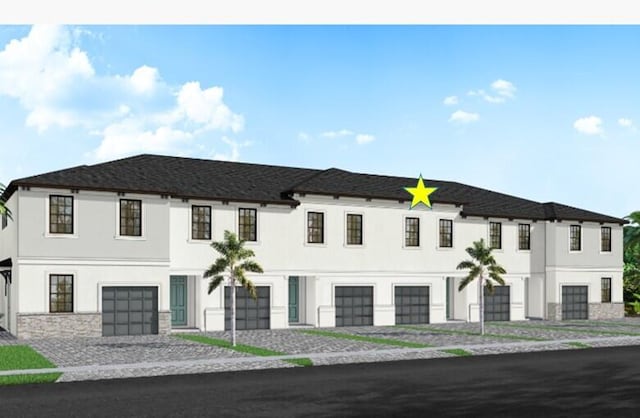 view of front facade featuring stucco siding, driveway, and a garage