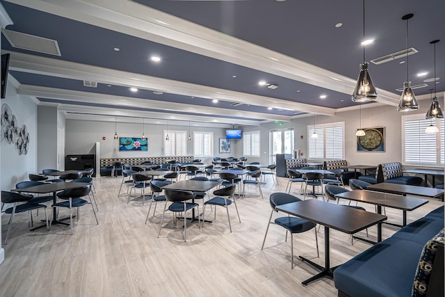 dining space featuring light wood-style floors, visible vents, and beamed ceiling