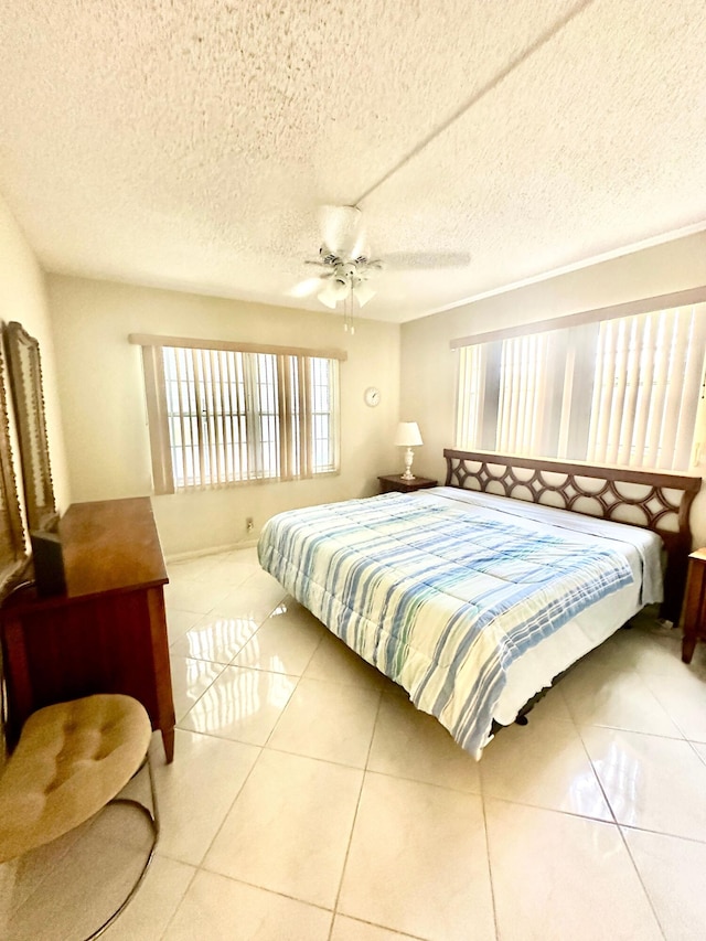 tiled bedroom featuring ceiling fan and a textured ceiling