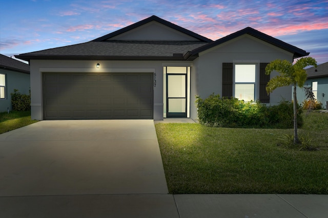 ranch-style house with a garage, a front yard, concrete driveway, and stucco siding