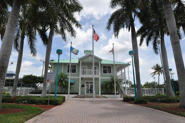 view of property featuring decorative driveway and fence