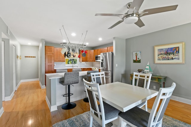 dining area featuring light wood-style flooring, baseboards, a ceiling fan, and recessed lighting