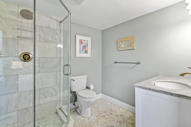 full bathroom featuring toilet, a stall shower, baseboards, and vanity