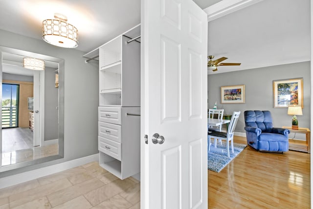 spacious closet with ceiling fan and light wood-style flooring