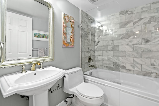 full bathroom featuring toilet, shower / bath combination with glass door, and a sink