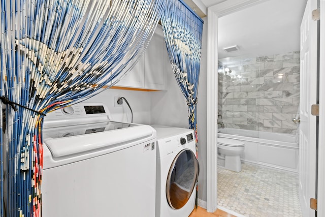 washroom featuring laundry area, visible vents, and separate washer and dryer