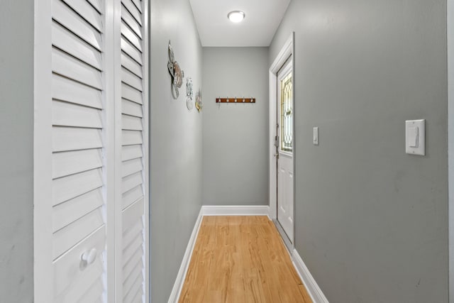 doorway to outside featuring light wood-type flooring and baseboards