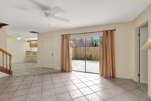 unfurnished room with baseboards, visible vents, a ceiling fan, stairway, and light tile patterned flooring