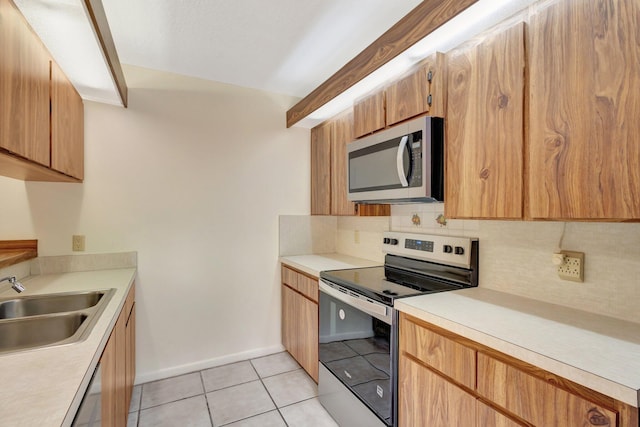 kitchen featuring a sink, light countertops, stainless steel appliances, backsplash, and light tile patterned flooring