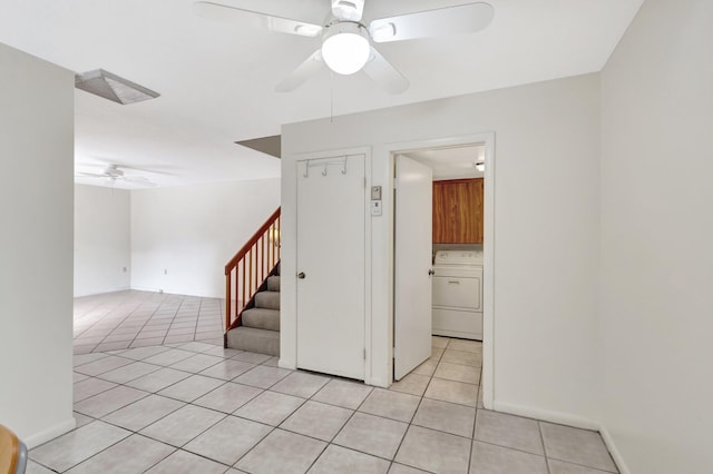 unfurnished room with light tile patterned flooring, a ceiling fan, baseboards, stairs, and washer / clothes dryer