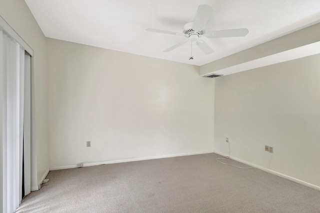 unfurnished room with a ceiling fan, light colored carpet, visible vents, and baseboards