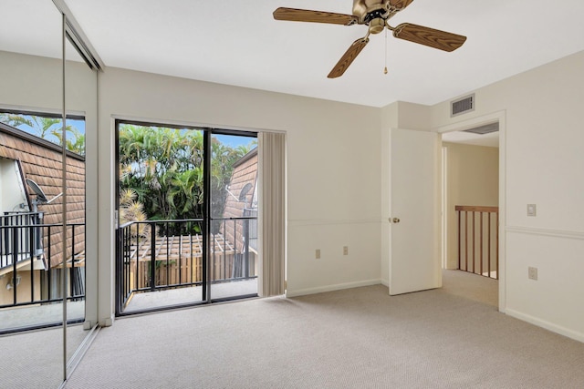 carpeted spare room with a ceiling fan, visible vents, and baseboards