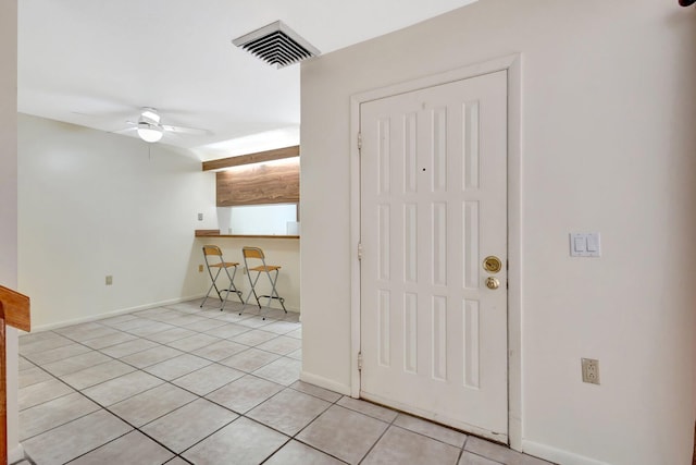 interior space featuring ceiling fan, visible vents, baseboards, and light tile patterned flooring