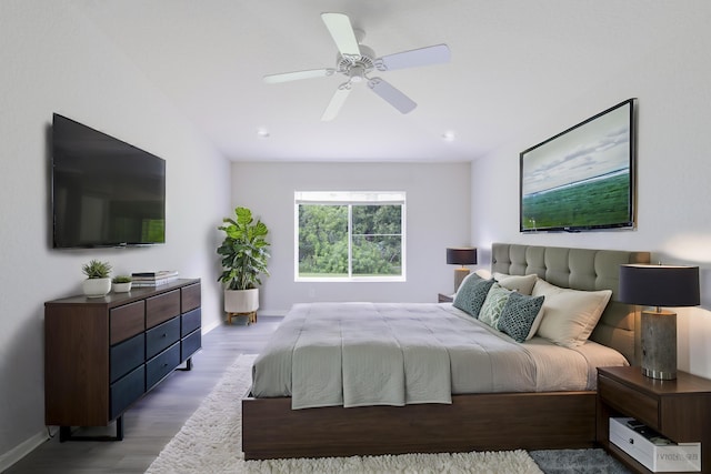 bedroom with light wood finished floors, a ceiling fan, and baseboards