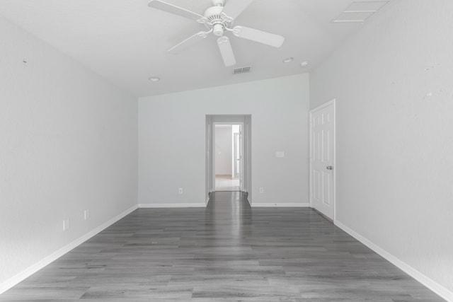 spare room featuring dark wood-style floors, baseboards, visible vents, and a ceiling fan