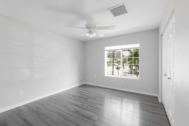 unfurnished bedroom featuring dark wood-type flooring, a closet, visible vents, and baseboards