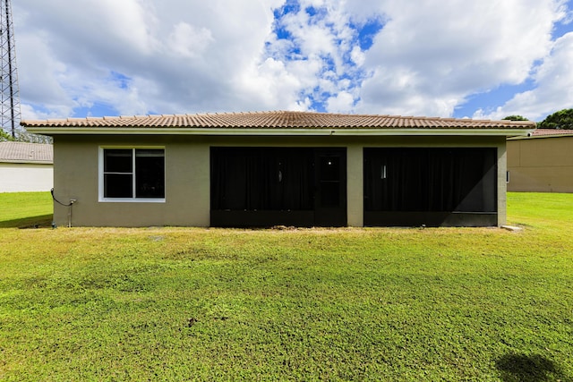 back of house with a yard and stucco siding