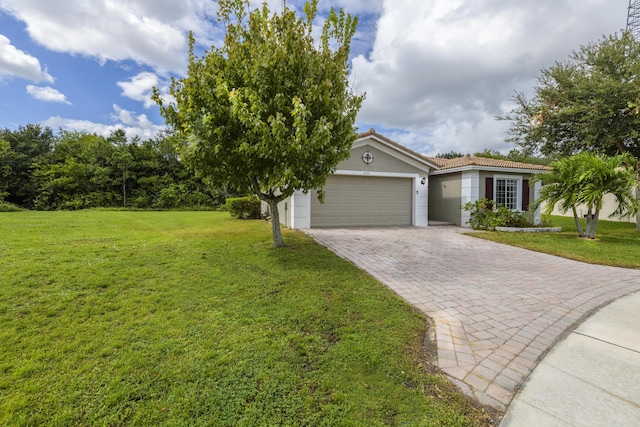 single story home with a garage, a tile roof, decorative driveway, and a front yard