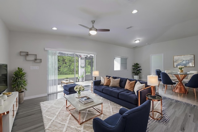 living room with baseboards, vaulted ceiling, wood finished floors, and recessed lighting