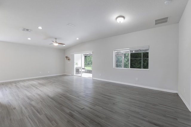 empty room featuring dark wood-type flooring, visible vents, and baseboards