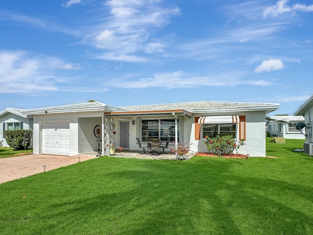 single story home featuring a garage, a front yard, decorative driveway, and stucco siding