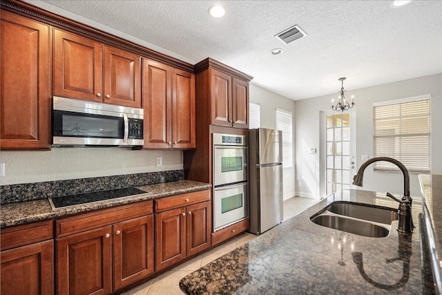 kitchen featuring light tile patterned floors, visible vents, appliances with stainless steel finishes, and a sink