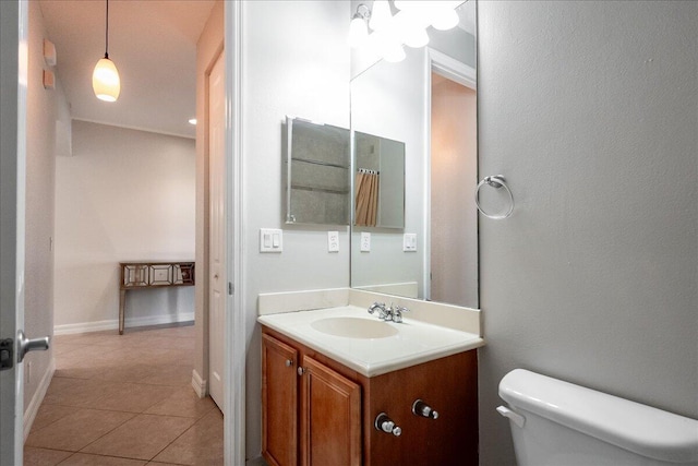 bathroom featuring toilet, tile patterned floors, baseboards, and vanity