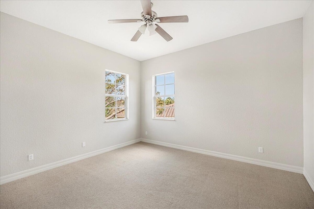 spare room with carpet flooring, a ceiling fan, and baseboards