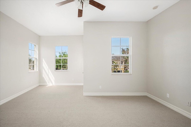 carpeted empty room with plenty of natural light, baseboards, and ceiling fan