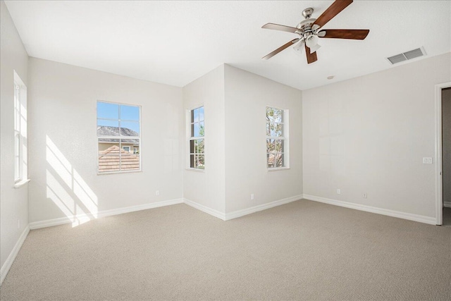 spare room with light carpet, baseboards, and visible vents