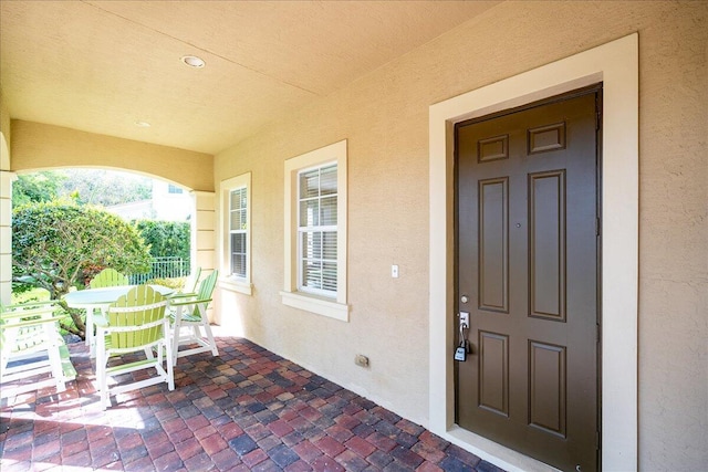 doorway to property featuring stucco siding