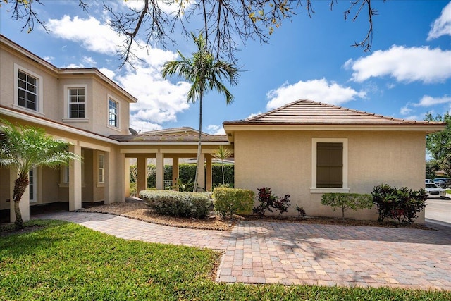 exterior space with a tile roof and stucco siding