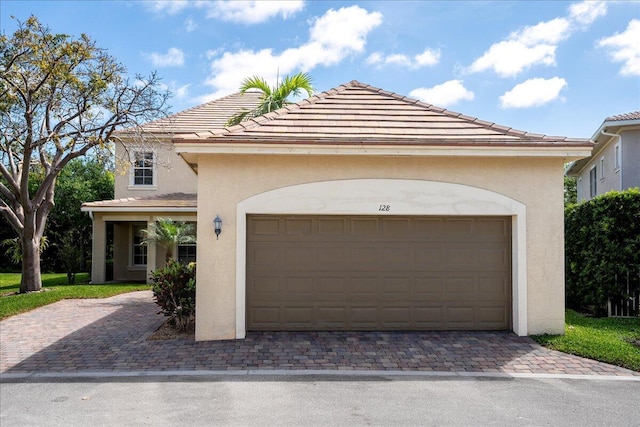 view of front of house with driveway, a tiled roof, and stucco siding