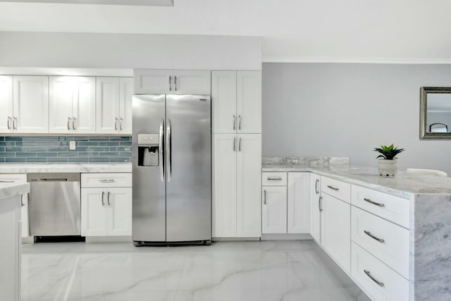 kitchen featuring a peninsula, white cabinets, marble finish floor, appliances with stainless steel finishes, and crown molding