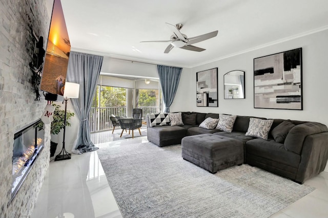 tiled living area featuring a large fireplace, crown molding, and ceiling fan