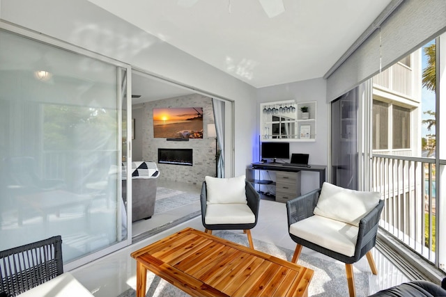 interior space featuring a large fireplace and ceiling fan