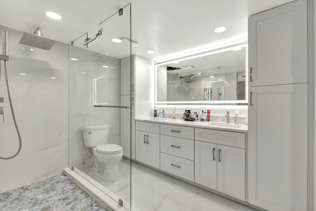 bathroom with double vanity, a marble finish shower, and a sink