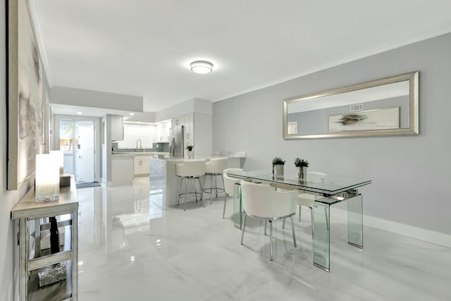 dining room with baseboards, marble finish floor, and crown molding