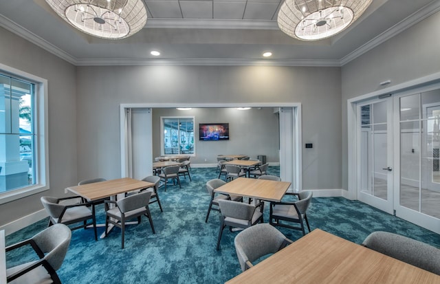 carpeted dining space featuring ornamental molding, french doors, a raised ceiling, and a notable chandelier